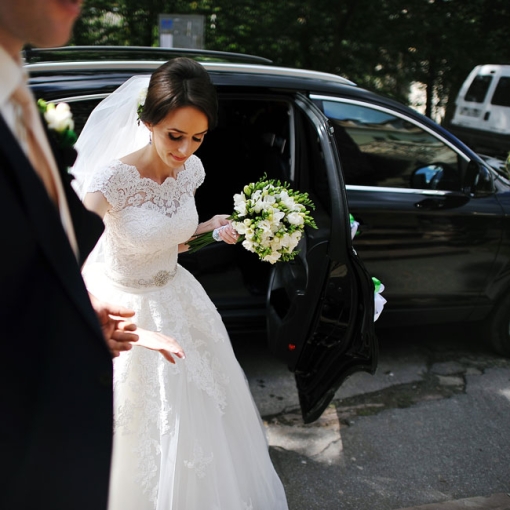 Bride exiting luxury black car